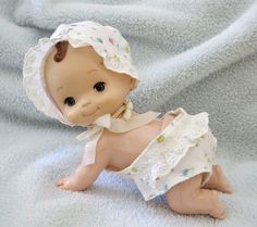 a baby doll is laying on a blanket