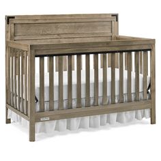 a wooden crib with white sheets on the bottom and side rails, against a white background