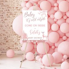 a baby shower sign surrounded by pink balloons