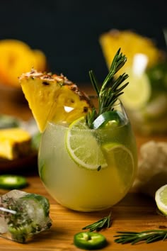 a drink with lemon and rosemary garnish in a glass on a wooden table