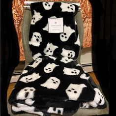 a black and white teddy bear blanket with skulls on it, sitting in a chair