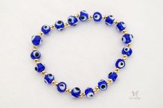 Esta es una auténtica y original pulsera Blue Evil Eye. Una de las razones más comunes para usar el brazalete contra el mal de ojo es protegerse de todo mal o negatividad en su vida.

 El ojo de Nazar se considera uno de los símbolos más poderosos del mundo. Trae protección, paz y buena suerte a tu vida colgando este exclusivo dije de mal de ojo que te mantendrá a salvo de cualquier negatividad.

 Esta pulsera es perfecta para alguien que quiere un regalo económico para ella o para otra persona. Esta pulsera hecha a mano está hecha a mano con cuentas azules de 6 mm y cuentas doradas de 6 mm, cuentas de metal de cobre bañadas en oro falso. Todos los materiales son duraderos y durarán años. Puedes usarlo con cualquier atuendo o ponerlo en la mesa de tu oficina para traerte buena suerte. Symbolic Blue Bracelet Jewelry, Blue Hypoallergenic Evil Eye Bracelet As Gift, Hypoallergenic Blue Evil Eye Bracelet Gift, Adjustable Blue Symbolic Bracelet, Blue Evil Eye Jewelry For Meditation, Blue Round Evil Eye Bracelets, Blue Evil Eye Round Bracelets, Blue Hypoallergenic Spiritual Bracelets, Blue Evil Eye Round Beaded Bracelets