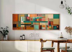 a painting hanging on the wall above a dining room table