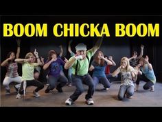 a group of young people dancing in front of a sign that says boom chicka boom