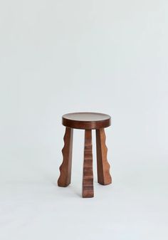 a small wooden stool sitting on top of a white floor