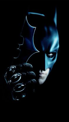 the dark knight rises poster with batman's face and hands on his chest,