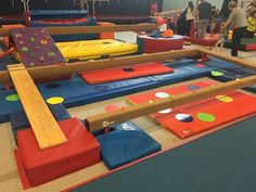 children playing in an indoor play area with soft foam mats and colorful bouncy tiles