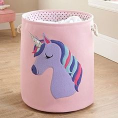 a pink toy bin with a unicorn face on it