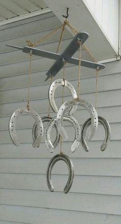 an airplane is hanging from the side of a house with horseshoes attached to it