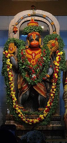 the statue is decorated with flowers and garlands