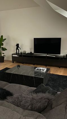 a living room filled with furniture and a flat screen tv on top of a wooden table