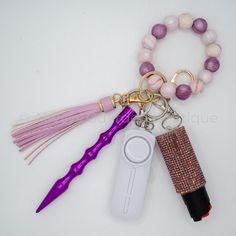 an assortment of items are displayed on a white surface, including a purple toothbrush and beaded keychain