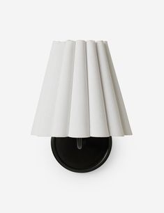 a black wall light with white shades on it