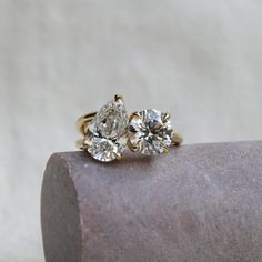 two diamond rings sitting on top of a rock