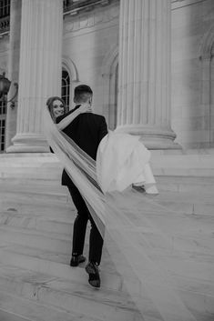 black and white photo of bride and groom in front of an old building with columns