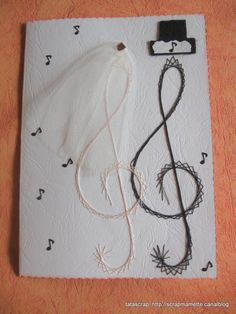 a piece of paper that has music notes on it and a string attached to it