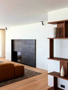 a living room with a couch, book shelf and fireplace