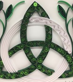 an intricately designed piece of art made out of white and green paper with spirals