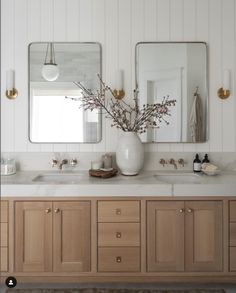 a bathroom with two sinks and mirrors on the wall