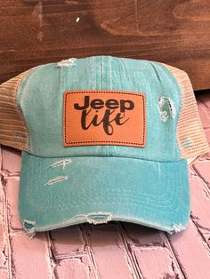 a teal trucker hat with the words jeep life written on it and a brown leather patch