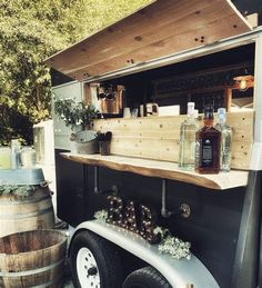 an outdoor bar with wooden barrels and bottles