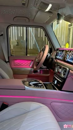 the interior of a car with pink trim and leather seats, including an electronic display