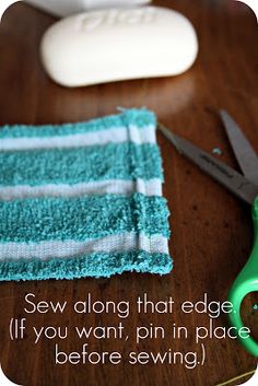 a pair of green scissors sitting on top of a wooden table next to a towel