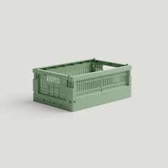 a green plastic crate sitting on top of a gray surface