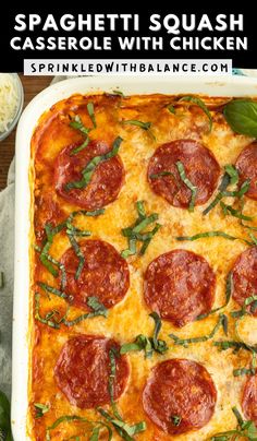 a square casserole dish with pepperoni and spinach garnished with cheese