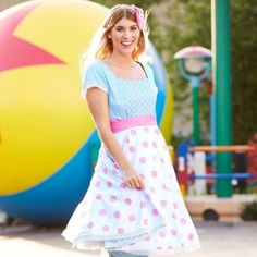 a woman standing in front of a giant ball at the park with her hands on her hips