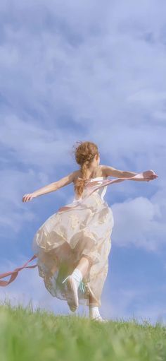 a woman in a dress is running with a frisbee