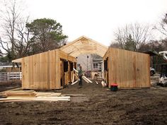 two men are working on the construction of a house that's being built with wood