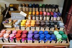 an assortment of spices and condiments for sale on a wooden stand in a store