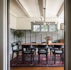 a dining room table with chairs and a rug on the floor in front of it