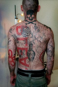 the back of a man with tattoos on his body