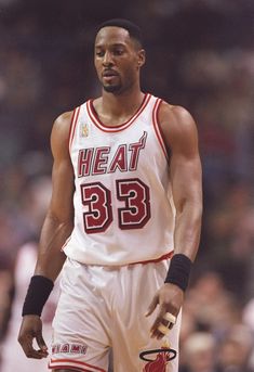 a basketball player standing on the court with his hand in his pocket and holding a ball