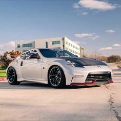 a white sports car parked in front of a building