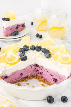 a blueberry cheesecake with lemon slices on the top is cut in half and ready to be eaten