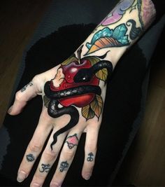 a woman's hand with tattoos and an apple on it