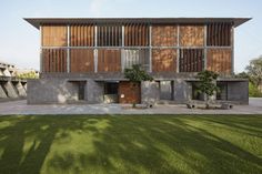 an architecturally designed concrete building with wooden slats on the front and side walls