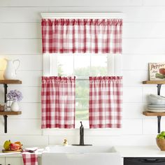 a kitchen with red and white checkered curtains hanging on the window sill, next to a sink