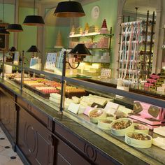 a buffet with lots of different types of food on it's counter top and lights hanging from the ceiling