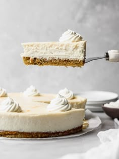 a piece of cheesecake being lifted by a fork from a plate with the rest of the cake on it