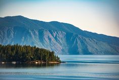 an island in the middle of a lake surrounded by mountains