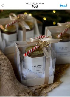 small jars with candy canes in them sitting on a table next to a christmas tree