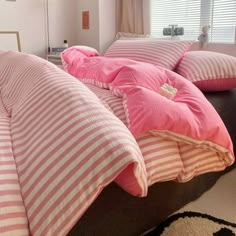 a bed with pink and white striped pillows