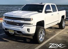 a white truck is parked on the beach