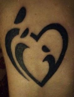 a black heart tattoo on the back of a person's leg