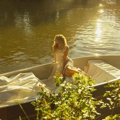 a woman is sitting in a boat on the water