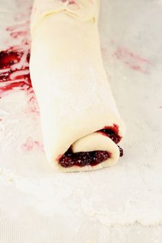 a rolled up pastry with cranberry sauce on it